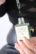 Form Uluxe skincare serum being dripped into a bottle with a blurred background