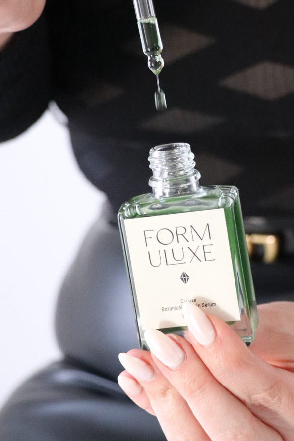 Form Uluxe skincare serum being dripped into a bottle with a blurred background